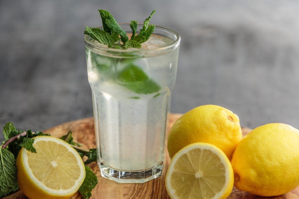 Cup of water with lemon and mint in it.