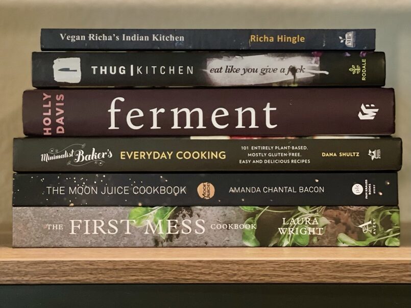 Cooking books stacked on a bookshelf.