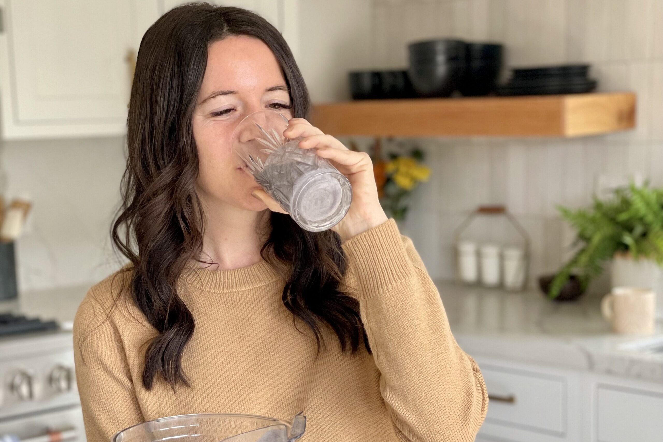 Woman drinking purple smoothie made in vitamix.