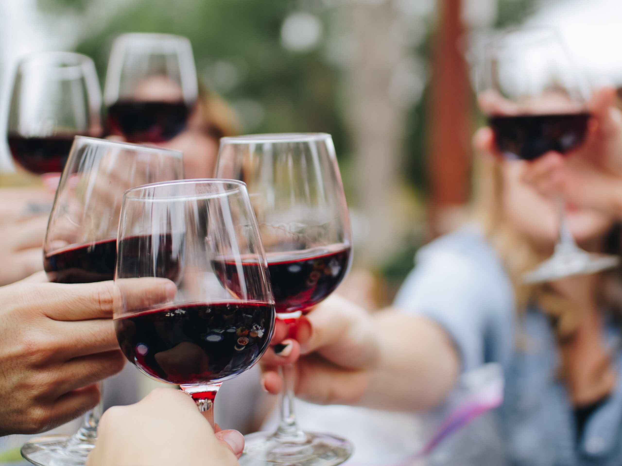 People doing a cheers with wine.