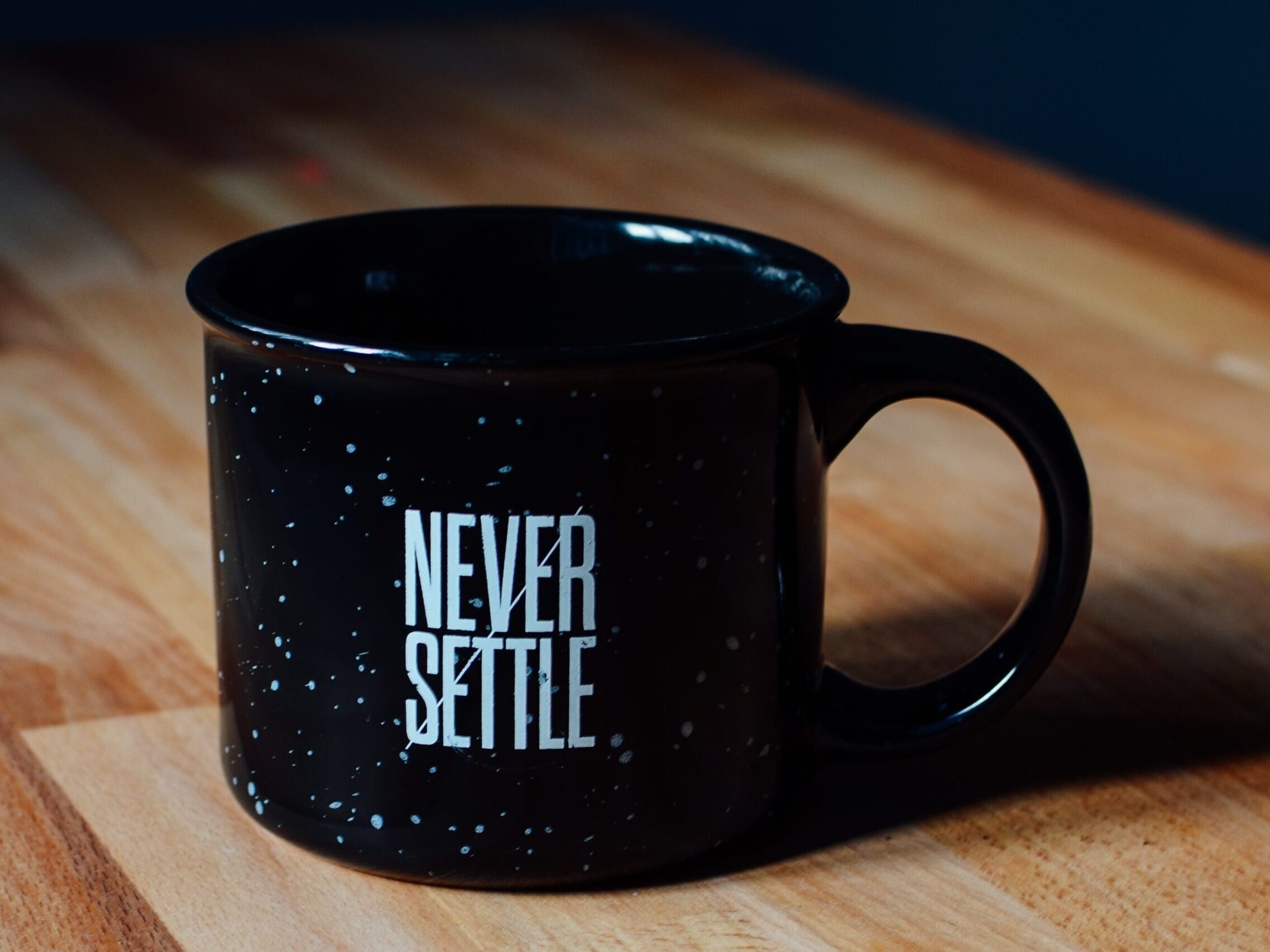 coffee mug that says "Never Settle".